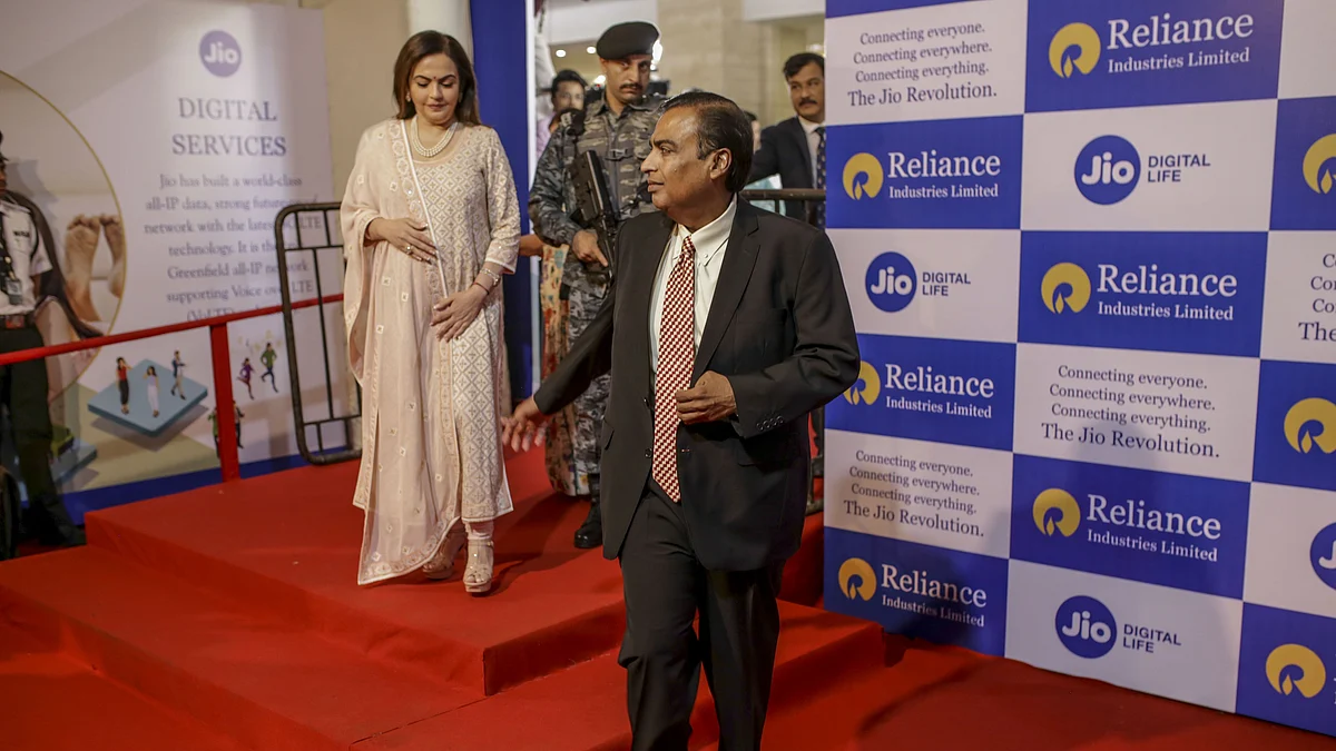 Mukesh Ambani, chairman and managing director of the Reliance Industries Ltd., right, and his wife Nita Ambani, left, arrive for the company’s annual general meeting in Mumbai, India. (Photographer: Dhiraj Singh/Bloomberg)
