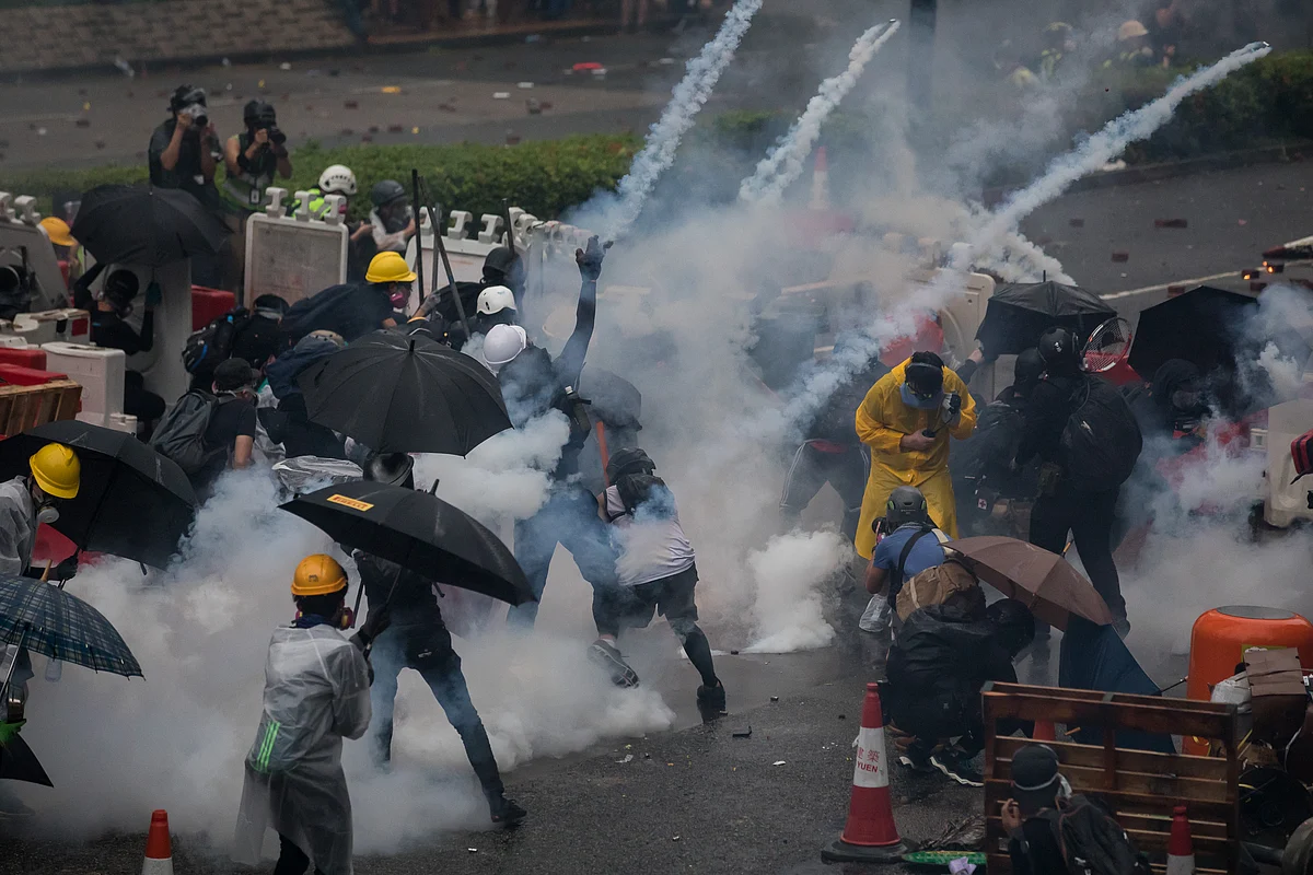 Demonstrators react to tear gas in the Tsuen Wan district of Hong Kong, on Aug. 25, 2019. (Photographer: Paul Yeung/Bloomberg)
