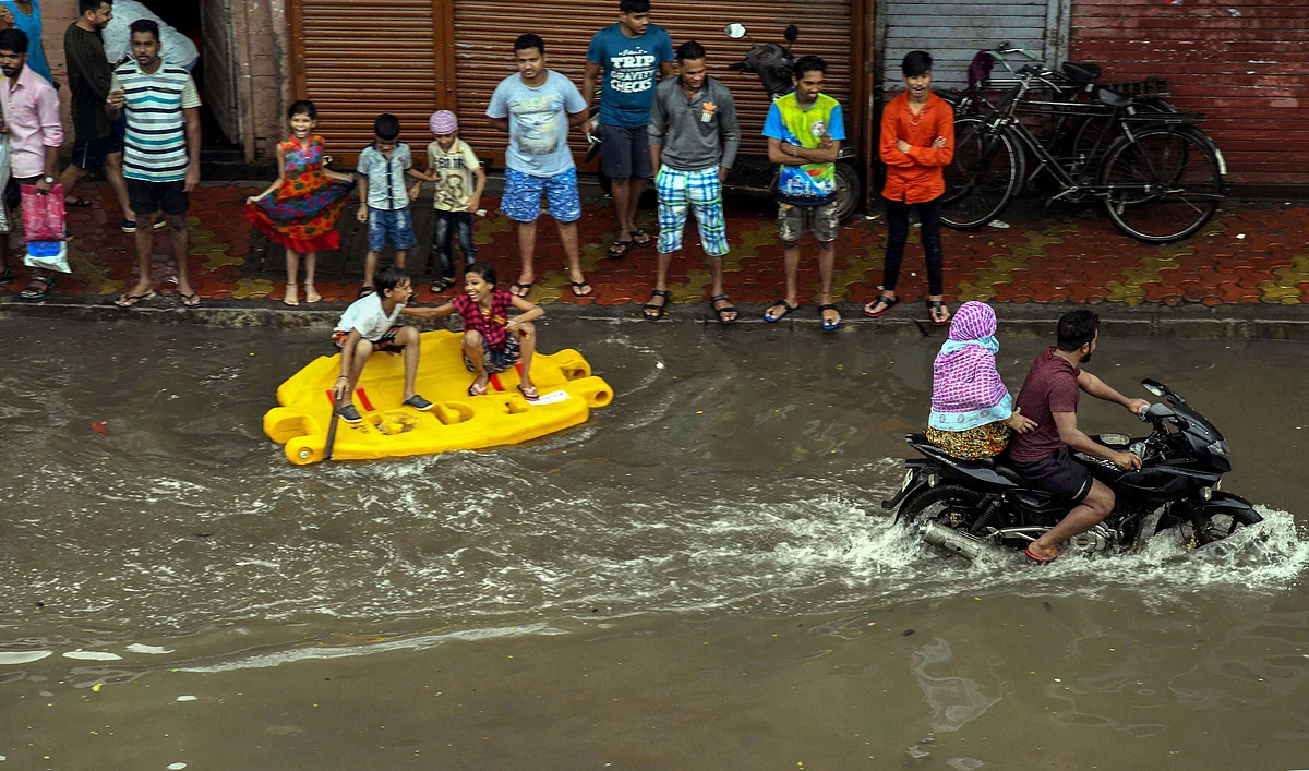People make their way through a flooded road in Mumbai, on Aug. 4, 2019. (Photograph: PTI)
