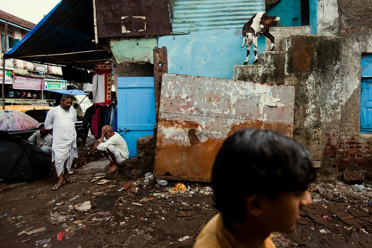A man passes on a garbage-strewn road in Dharavi, Mumbai. (Photographer: Prashanth Vishwanathan/Bloomberg)