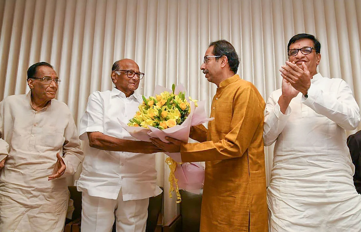 Sharad Pawar presents Uddhav Thackeray a bouquet of flowers. (Source: PTI)
