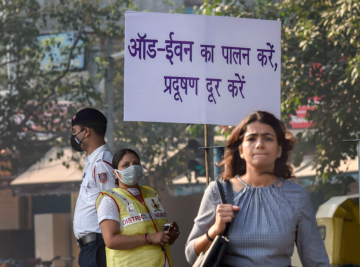 Civil Defence volunteer wearing a mask displays a placard asking people to obey the odd-even rule, in New Delhi (Source: PTI)