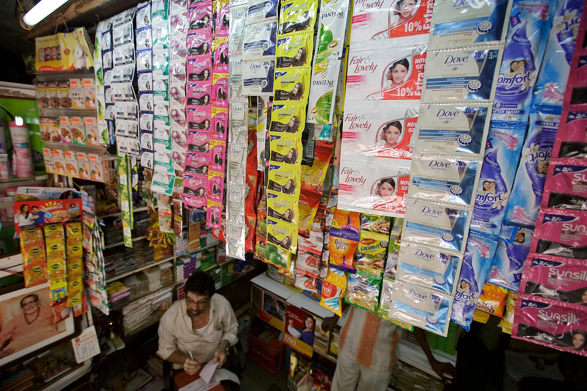 A file photograph of a store attendant sits beneath sachets of Hindustan Unilever Ltd. products. (Photographer: Kuni Takahashi/Bloomberg)