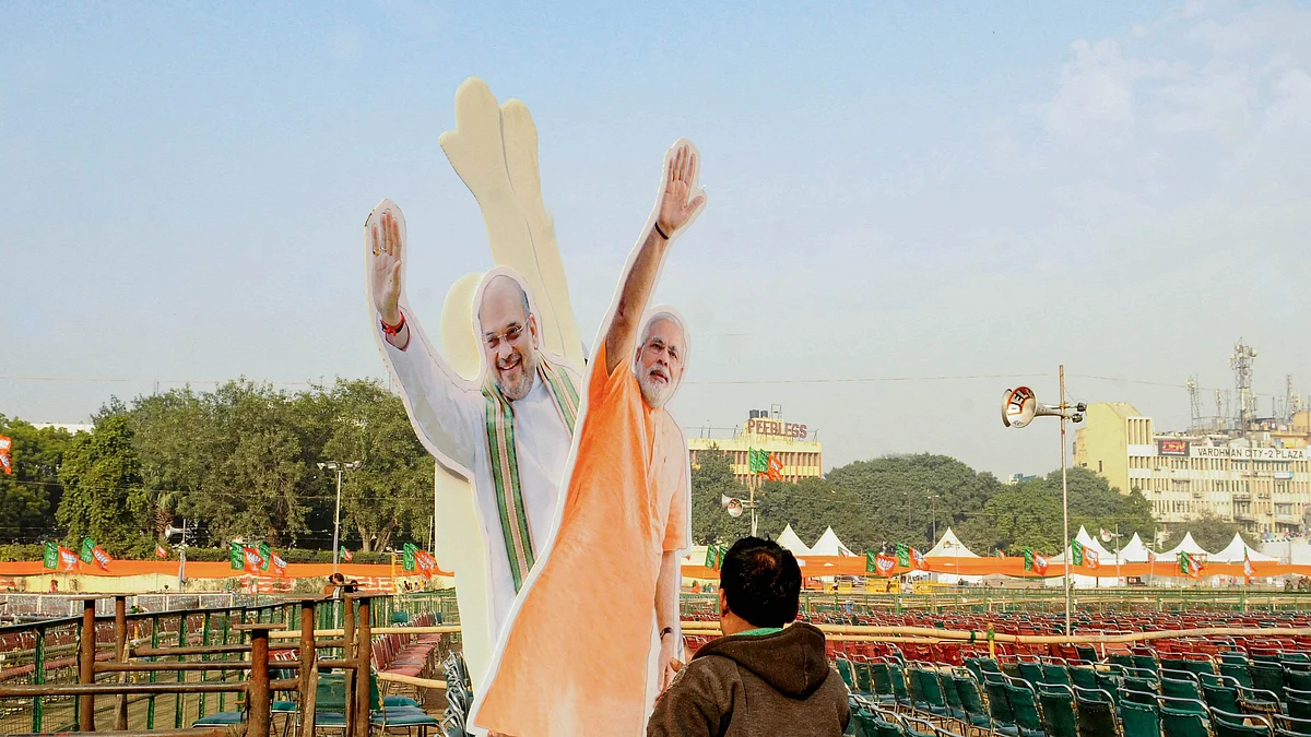 A workers carries cut-outs of Prime Minister Narendra Modi and Union Home Minister Amit Shah (Source: PTI)