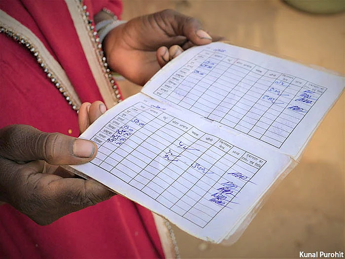 Shakila Bibi, 28, displays her ration card which shows the gaps in supply of rations.