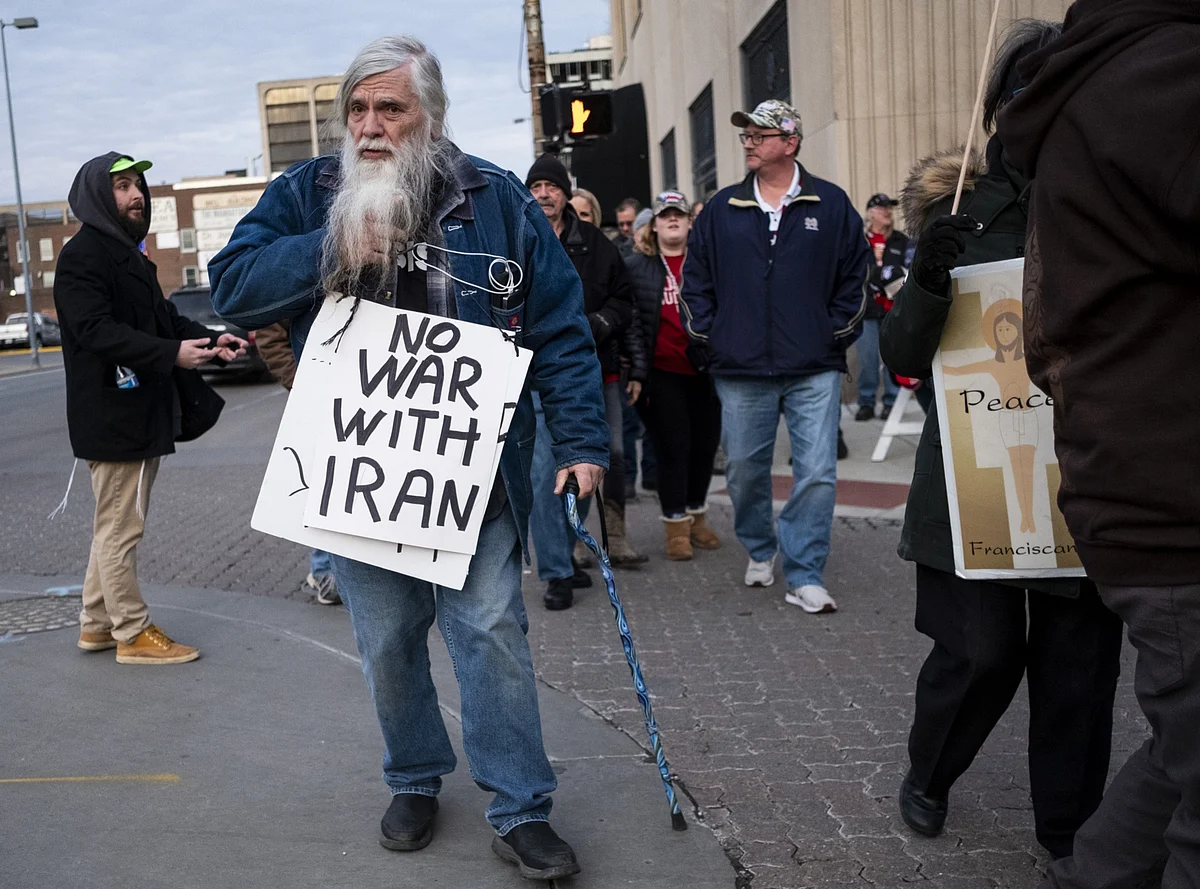 A demonstrators carries a sign reading “No War With Iran” during an anti-war protest in Toledo, Ohio. (Photographer: Matthew Hatcher/Bloomberg)