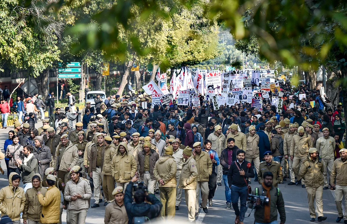 Police personnel walk in front of JNU students’ protest march from Mandi House to HRD Ministry, demanding removal of the university vice-chancellor, at Ferozeshah Road in New Delhi, Thursday, Jan. 9, 2020. (PTI Photo/Ravi Choudhary)