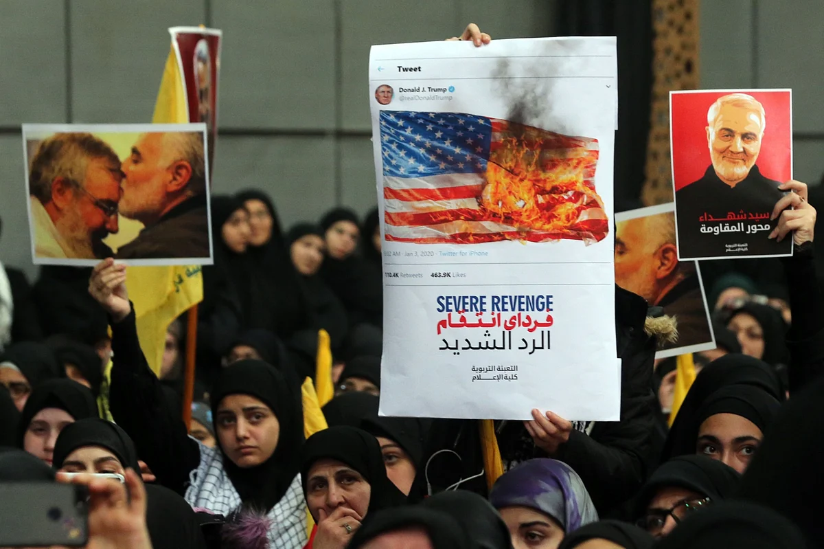 Hezbollah supporters hold pictures of Qassem Soleimani, an Iranian commander, as Hassan Nasrallah, leader of Hezbollah, delivers a televised speech, in Beirut. (Photographer: Hasan Shaaban/Bloomberg)