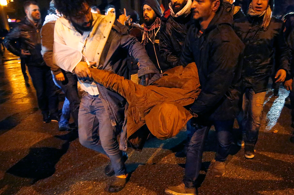 Anti-government protesters carry their friend who was injured by rubber bullet while clashing with the riot police, during ongoing protests against the political elites who have ruled the country since decades, in Beirut, Lebanon, Sunday, Jan. 19, 2020. (Source: AP Via PTI)