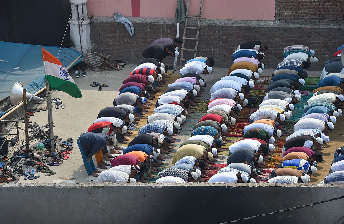 Muslims offer Friday prayers on the rooftop of a mosque, which was burnt by rioters (Source: PTI)