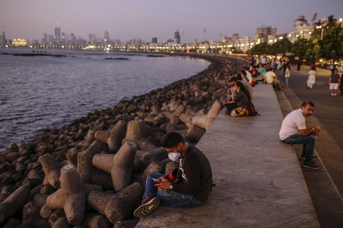 A person wearing a protective face mask uses a mobile phone at Marine Drive in Mumbai, India, on Monday, March 9, 2020. (Photographer: Dhiraj Singh/Bloomberg)