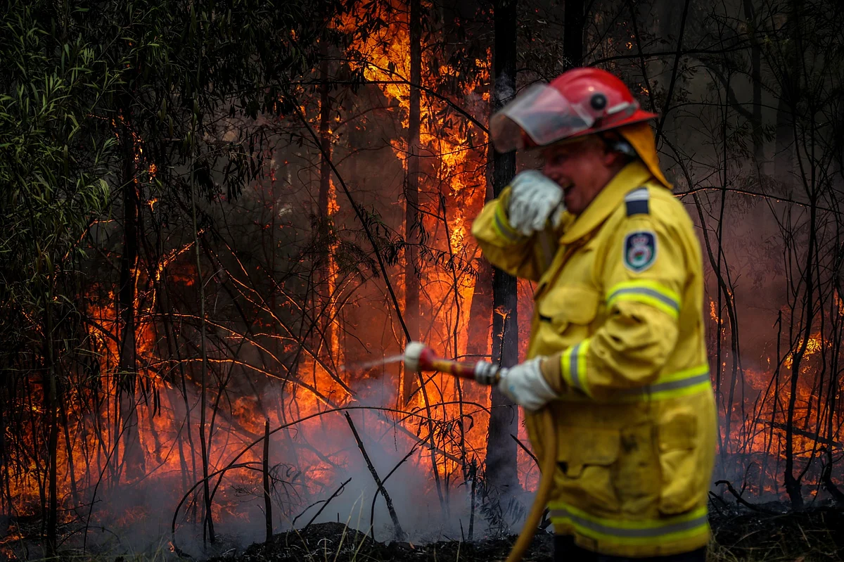 A volunteer dousing a fire in New South Wales, Australia. (Photographer: David Gray/Bloomberg)