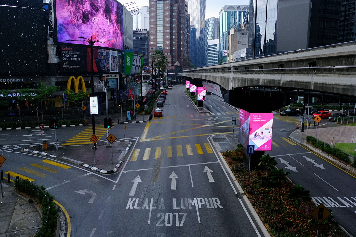 Closed stores line an empty road at Jalan Bandar near Petaling street in Kuala Lumpur, Malaysia, on Wednesday, March 18, 2020. Prime Minister Muhyiddin Yassin said late Monday that the country will be limiting non-essential businesses operations as well as banning all visitors from entering the country and residents from traveling overseas from March 18 for two weeks. (Photographer: Samsul Said/Bloomberg)