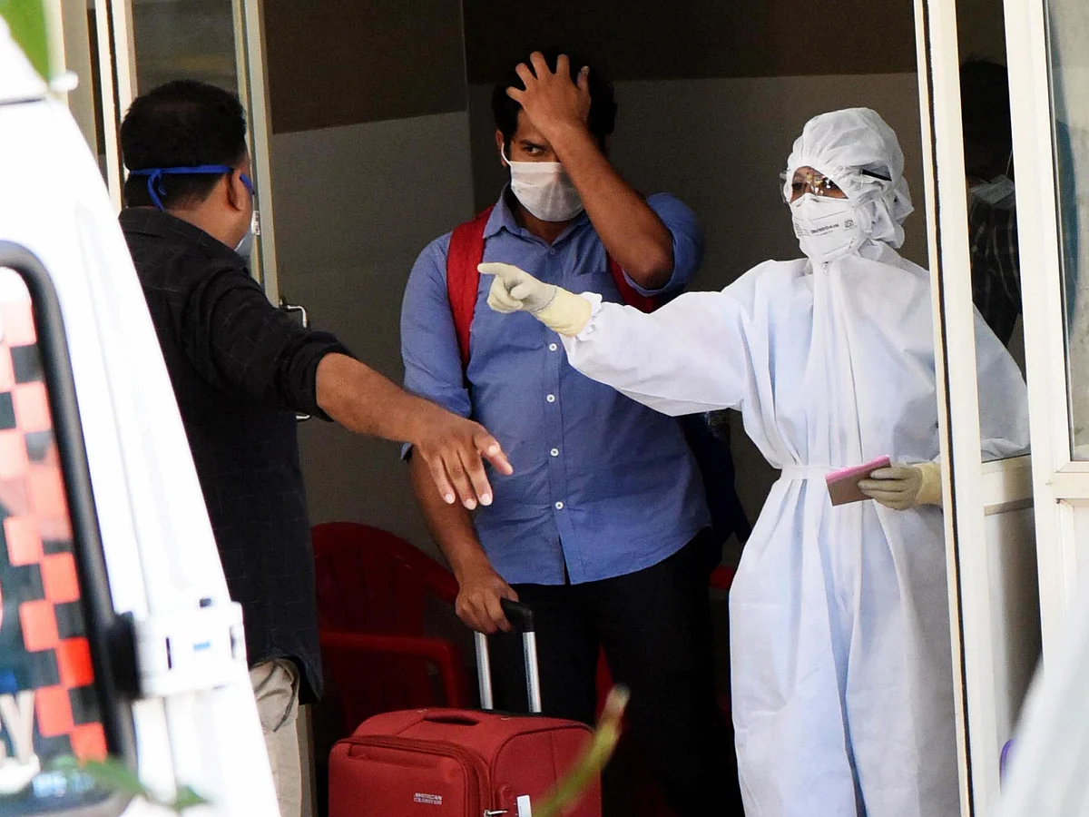A medic wearing protective suit interacts with patients outside an isolation ward, at a government general hospital in Kochi, Kerala, on March 15, 2020. (Photograph: PTI)