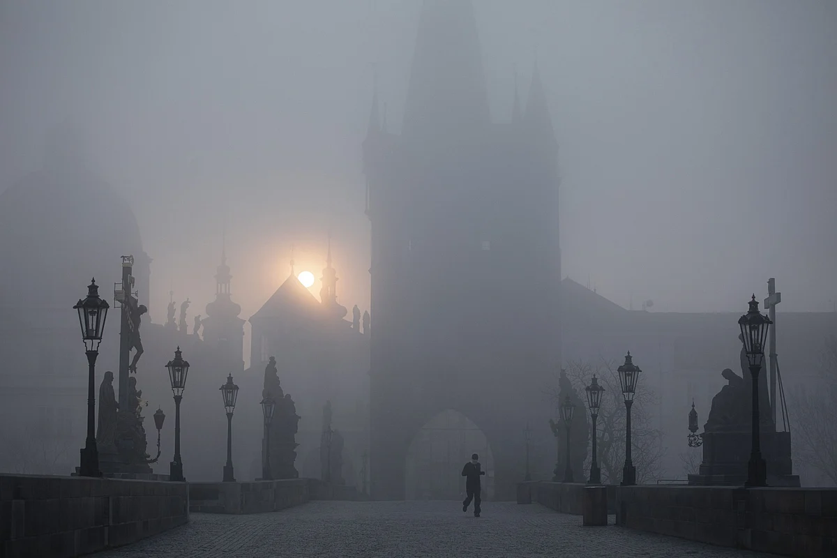 A runner jogs over an empty Charles Bridge at dawn in Prague, Czech Republic, on Wednesday, March 18, 2020. (Photographer: Milan Jaros/Bloomberg)