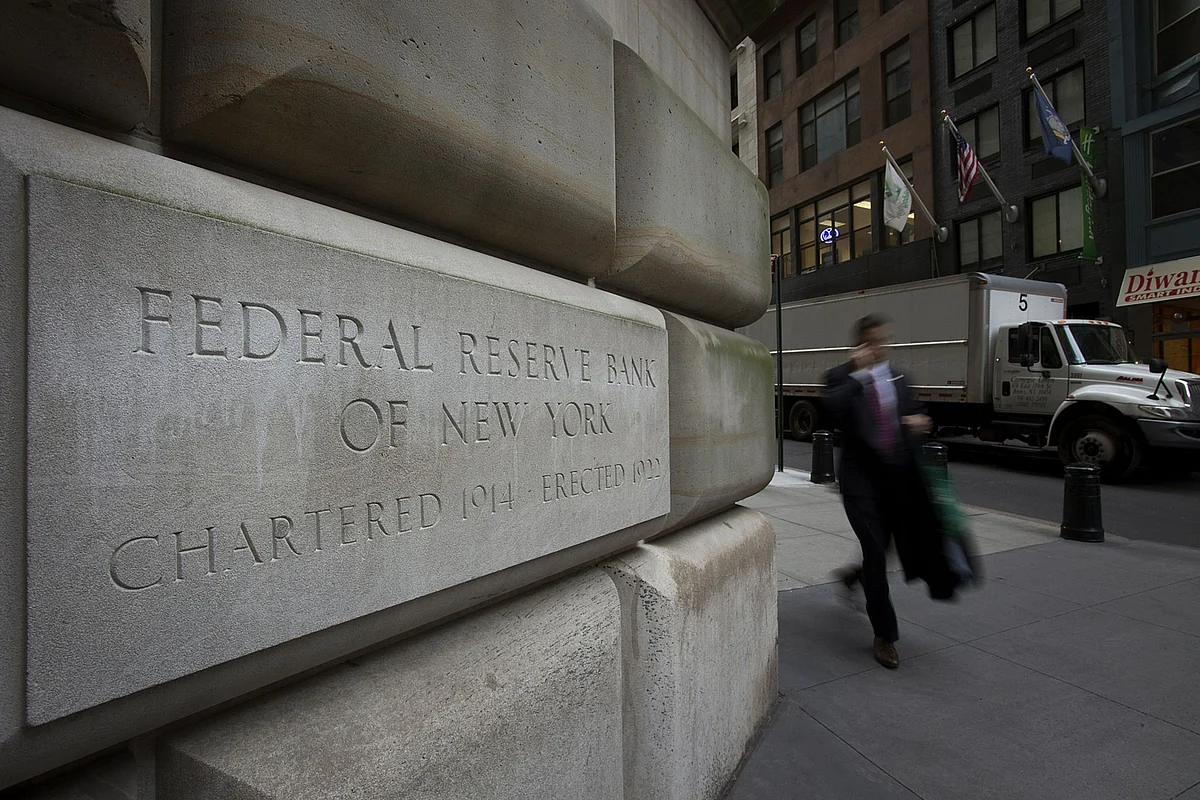 Pedestrians walk past the New York Federal Reserve building in New York. (Photographer: Scott Eells/Bloomberg)