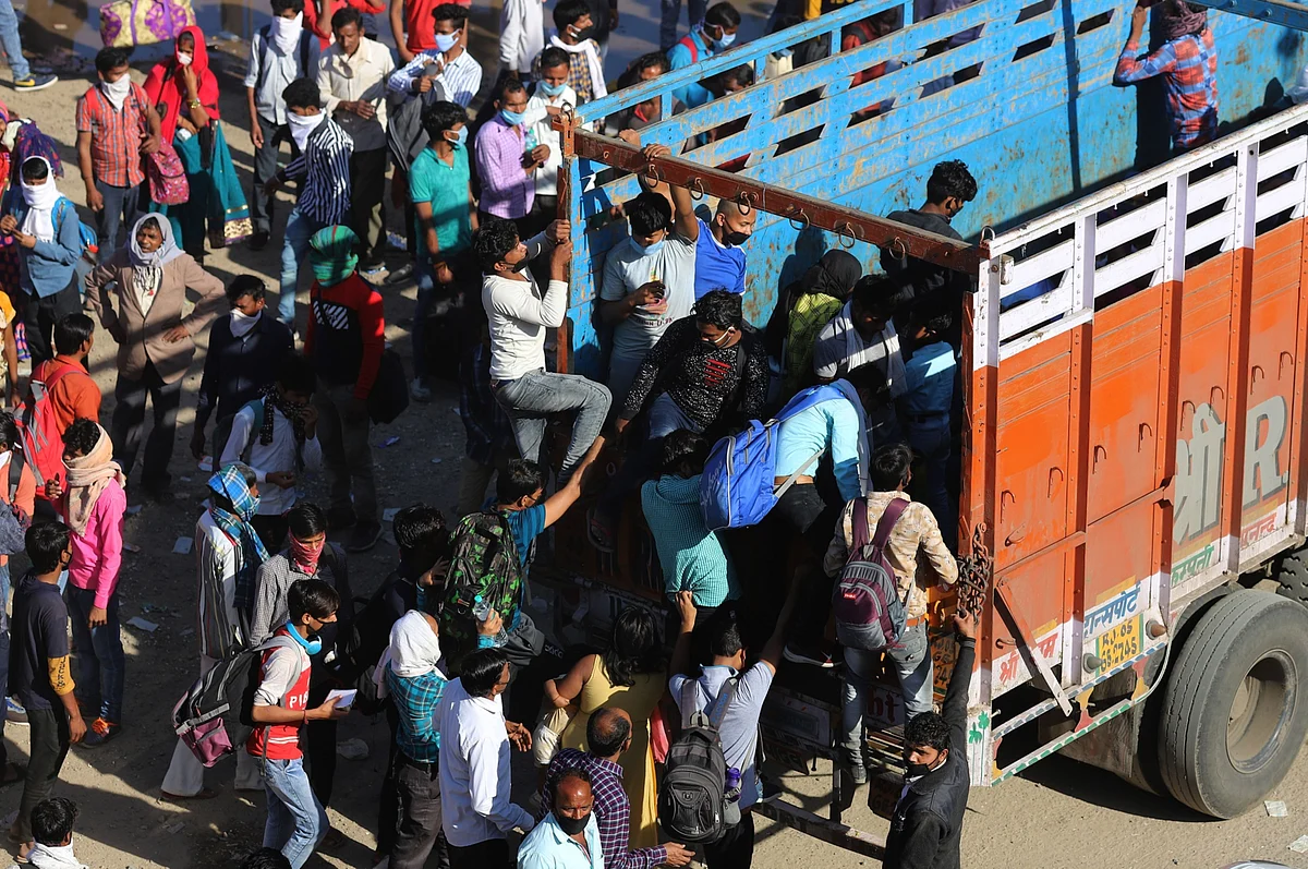 Migrant workers and their families climb onto a truck during a lockdown imposed due to the coronavirus in New Delhi, India, on Saturday, March 28, 2020. (Photographer: Anindito Mukherjee/Bloomberg)
