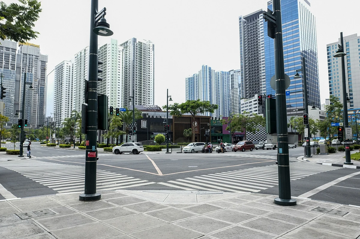 Vehicles travel through an intersection in Bonifacio Global City, Metro Manila, the Philippines, on Monday, March 16, 2020. The capital region started a lockdown from Sunday to contain the outbreak of the novel coronavirus amid a spike in cases. (Photographer: Veejay Villafranca/Bloomberg)