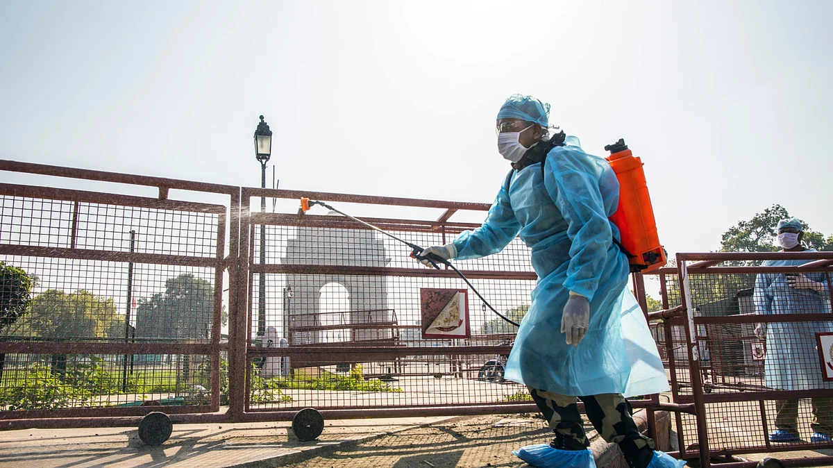A security personnel wearing a protective suit and mask sprays disinfectant near the India Gate monument, temporary closed due to the coronavirus, in New Delhi, India, on Sunday, March 22, 2020. (Photographer: Prashanth Vishwanathan/Bloomberg)
