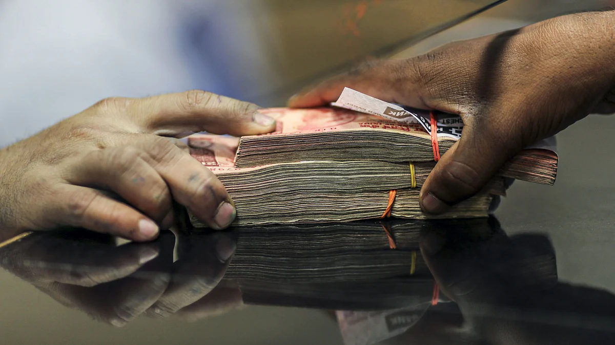 A customer withdraws a stack of Indian twenty rupee banknotes at a branch of the HDFC Bank Ltd. in Mumbai, India (Photographer: Dhiraj Singh/Bloomberg)