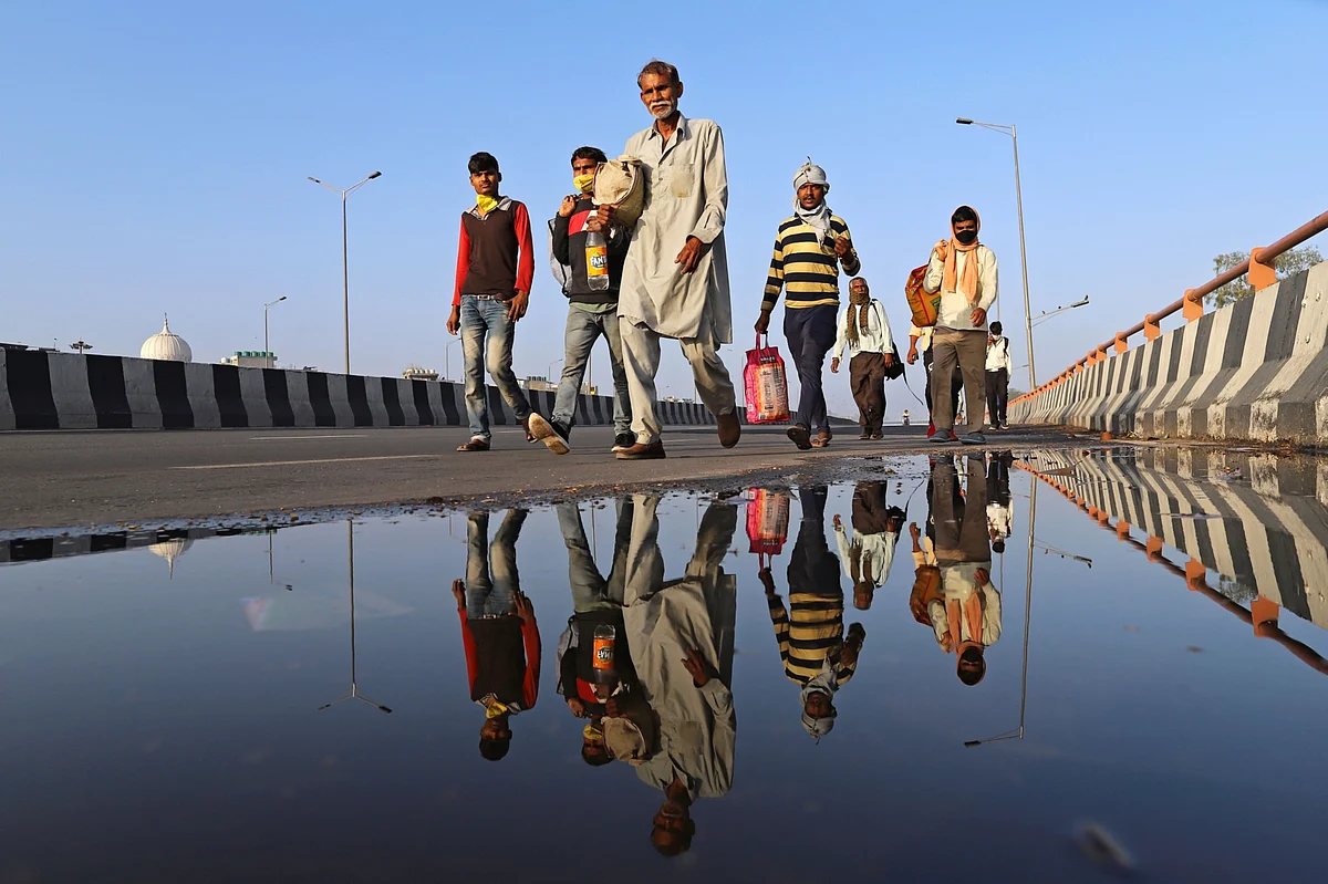 Migrant workers and their families walk along a road during a lockdown imposed due to the coronavirus in New Delhi, on March 28, 2020. (Photographer: Anindito Mukherjee/Bloomberg)