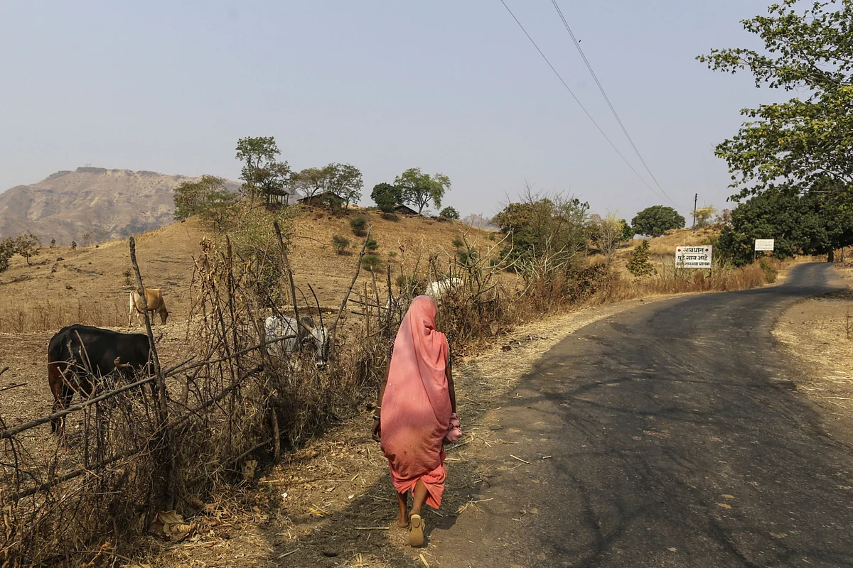 A woman walks along a road in Nadurbar district, Maharashtra. (Photographer: Dhiraj Singh/Bloomberg)