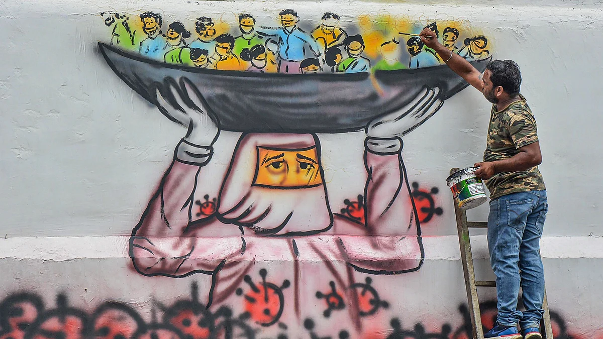 File picture of an artist painting a mural on a wall depicting a doctor saving people’s lives from coronavirus in Guwahati. (Source: PTI)