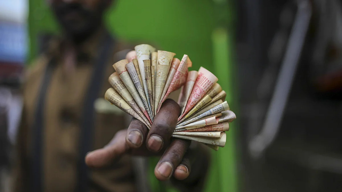 A bus conductor displays Indian bank rupee notes for a photograph in Coonoor, Tamil Nadu, India. (Photographer: Dhiraj Singh/Bloomberg)