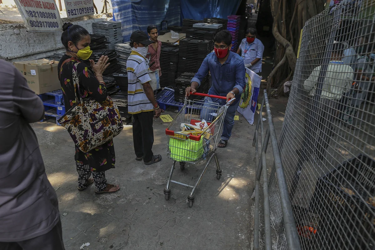 A shopper wearing a mask wheels a grocery cart, in Mumbai, on March 25, 2020. (Photographer: Dhiraj Singh/Bloomberg)
