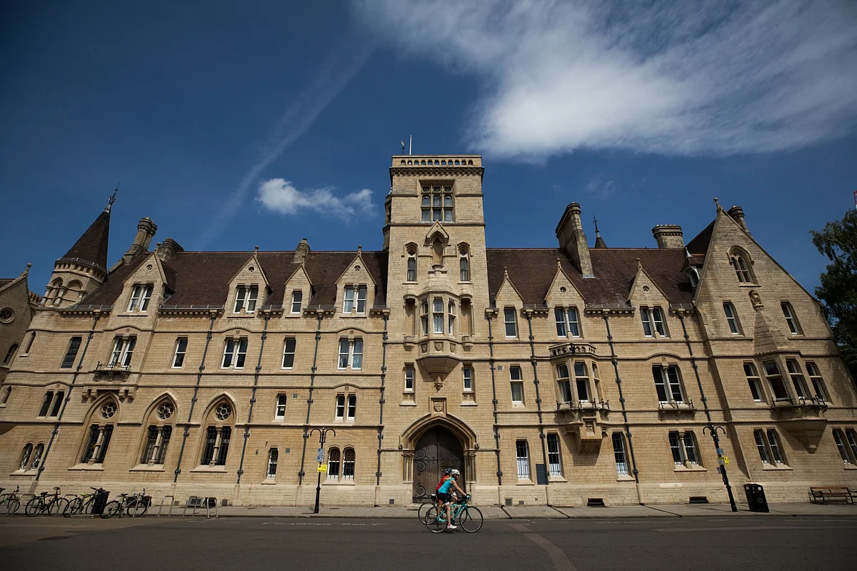 Cyclists pass Balliol college, part of the University of Oxford, in Oxford, U.K. (Photographer: Chris Ratcliffe/Bloomberg)