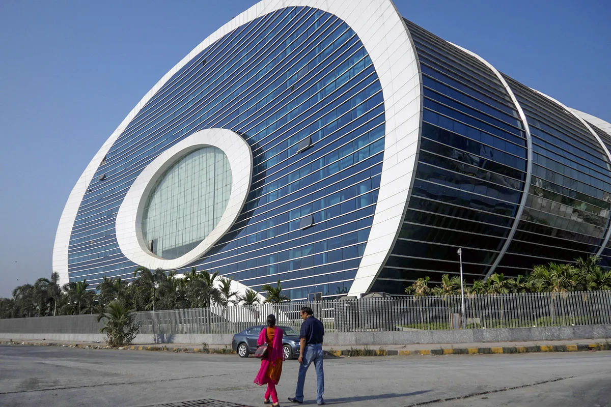 Pedestrians walk past the Oil and Natural Gas Corp. office at the Bandra Kurla Complex in Mumbai. Photographer: Dhiraj Singh/Bloomberg