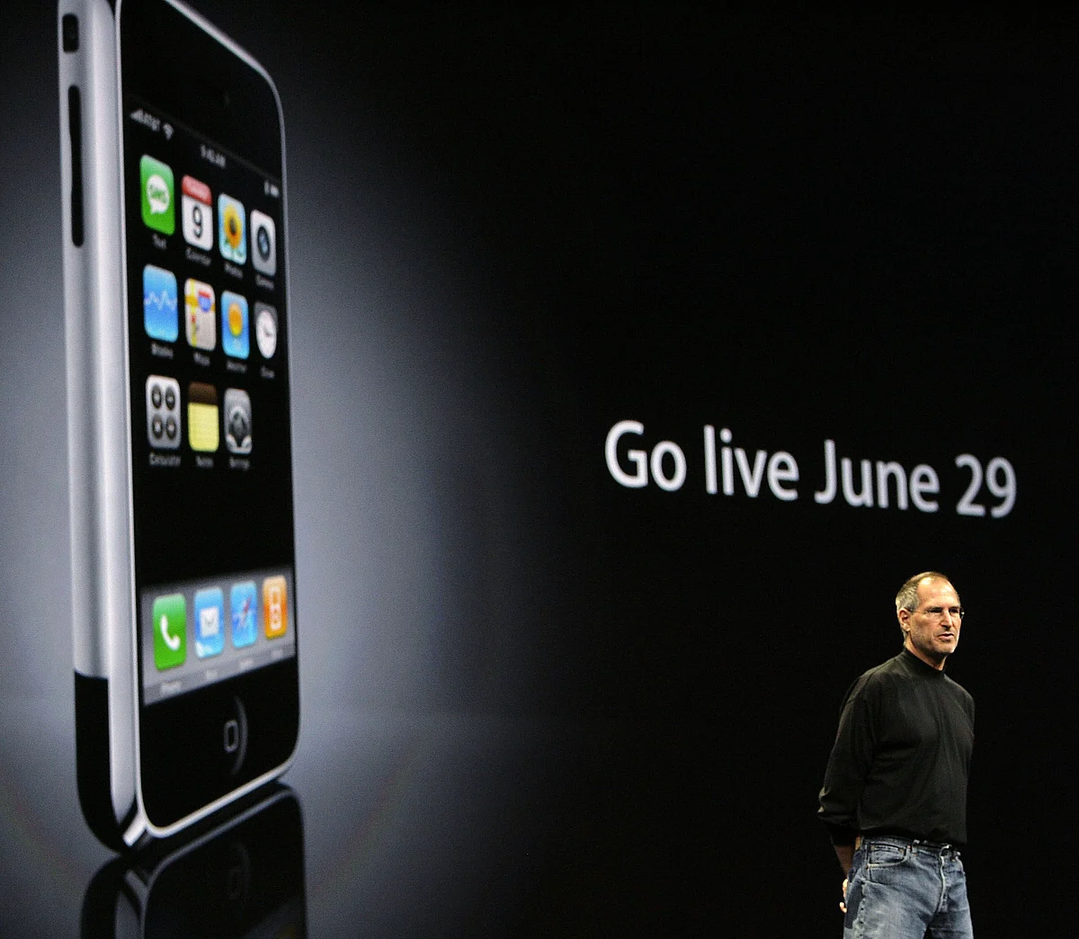 Steve Jobs speaks in front of a projection of the first iPhone ahead of its launch, in San Francisco, California, on June 11, 2007. (Photographer: Tony Avelar/Bloomberg News)