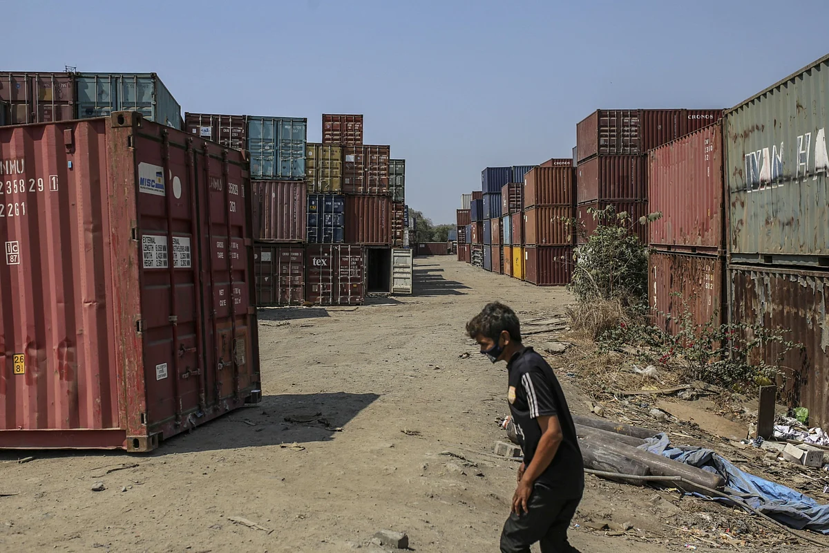 A worker in a mask crosses shipping containers JNPT, in Navi Mumbai, on March 30, 2020. (Photographer: Dhiraj Singh/Bloomberg)