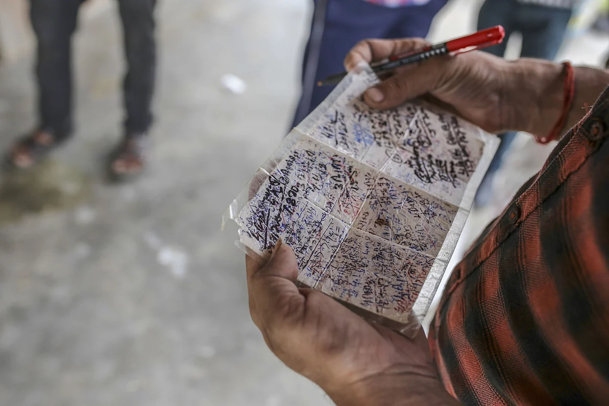 An official holds a handwritten note of distributed rations at a state-run store in a village in Tikamgarh district, Madhya Pradesh on Aug. 7, 2020. (Photographer: Dhiraj Singh/Bloomberg)