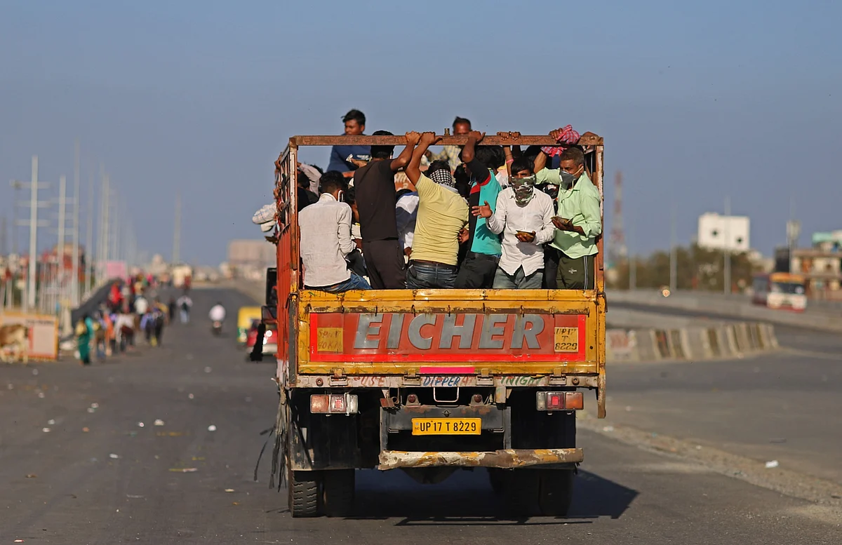 Migrant workers and their families ride on a truck during a lockdown (Photographer: Anindito Mukherjee/Bloomberg)