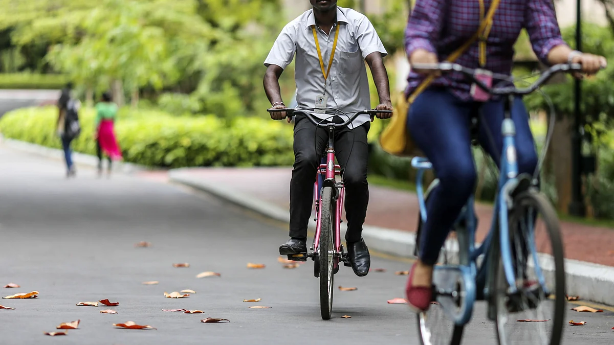 Trainees cycle through a residential area at the Infosys’ Global Education Centre campus in Mysore, India, on Aug. 22, 2017. (Photographer: Dhiraj Singh/Bloomberg)