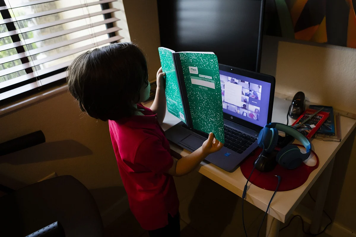 A student displays his notebook while attending an online class from home. (Photographer: Eva Marie Uzcategui / Bloomberg)