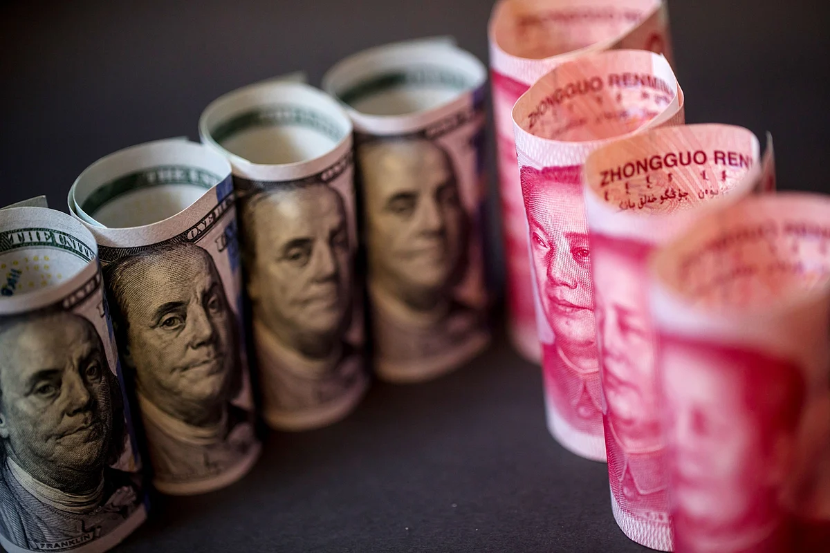 U.S. one-hundred dollar bills sit with a Chinese one-hundred yuan banknotes on a black background in this arranged photograph in Hong Kong, China. (Photographer: Paul Yeung/Bloomberg)