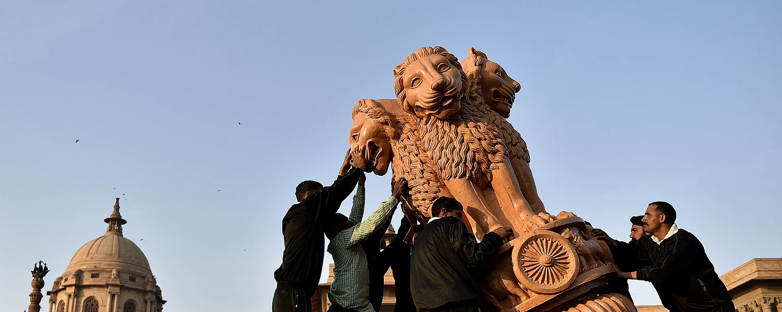 Workers unload a statue of the Ashoka Stambha outside the the Central Secretariat buildings, in New Delhi. (Photographer: Anindito Mukherjee/Bloomberg)