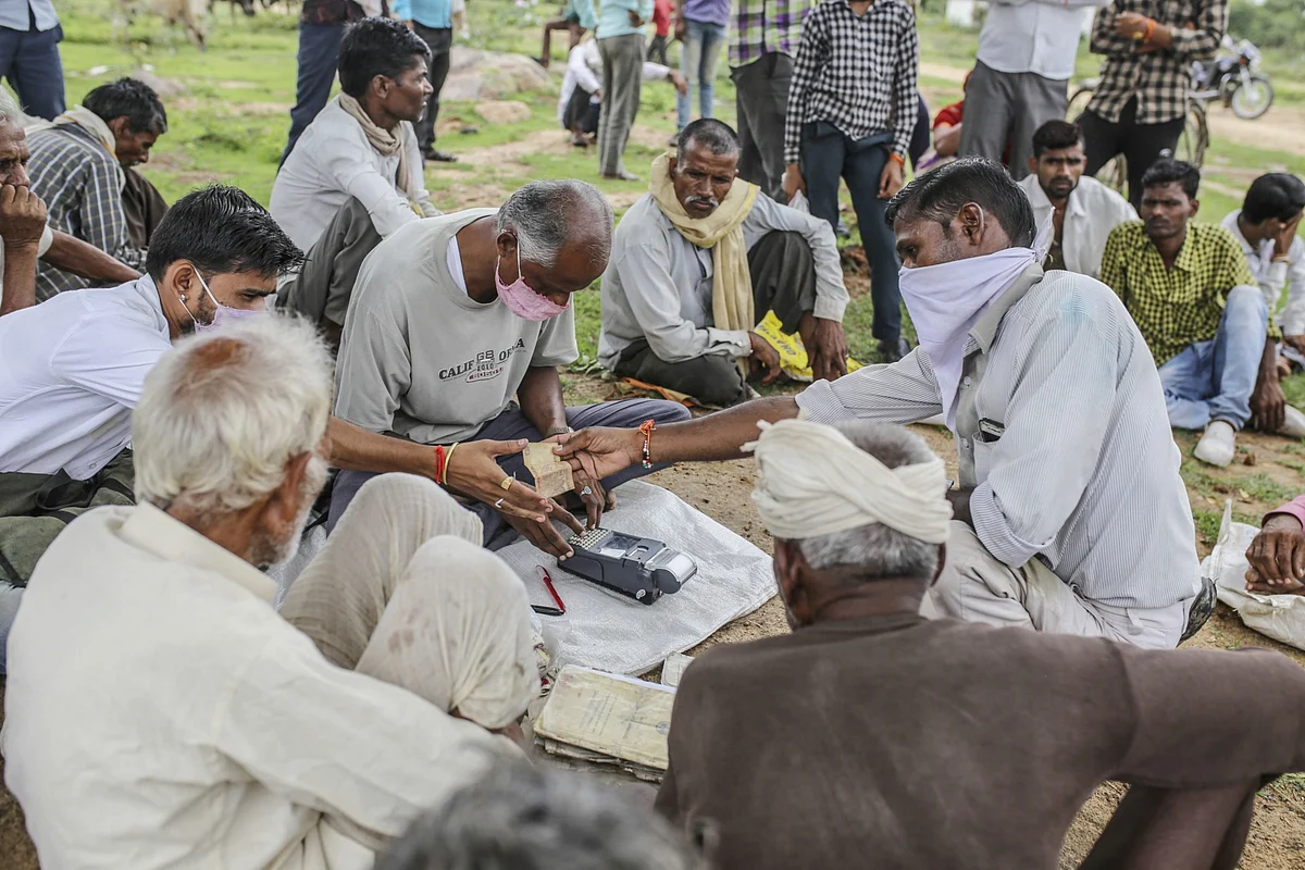 A government employee serves people at a state-run distribution store in a village in Tikamgarh district, Madhya Pradesh, on Aug. 7, 2020. (Photographer: Dhiraj Singh/Bloomberg)