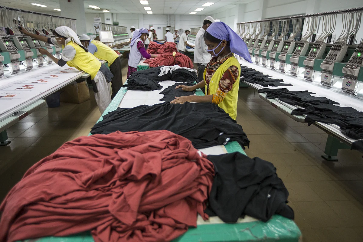 Workers embroider t-shirts with logos on the production line of a garment factory in Gazipur, Bangladesh, on May 30, 2013. (Photographer: Jeff Holt/Bloomberg)