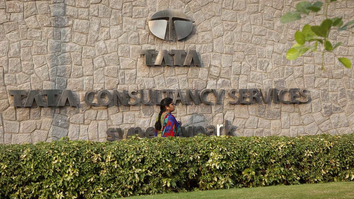 An employee walks past a signage for Tata Consultancy Services Ltd. (TCS) at the company’s Synergy Park campus in Hyderabad, India. (Photographer: Namas Bhojani/Bloomberg)