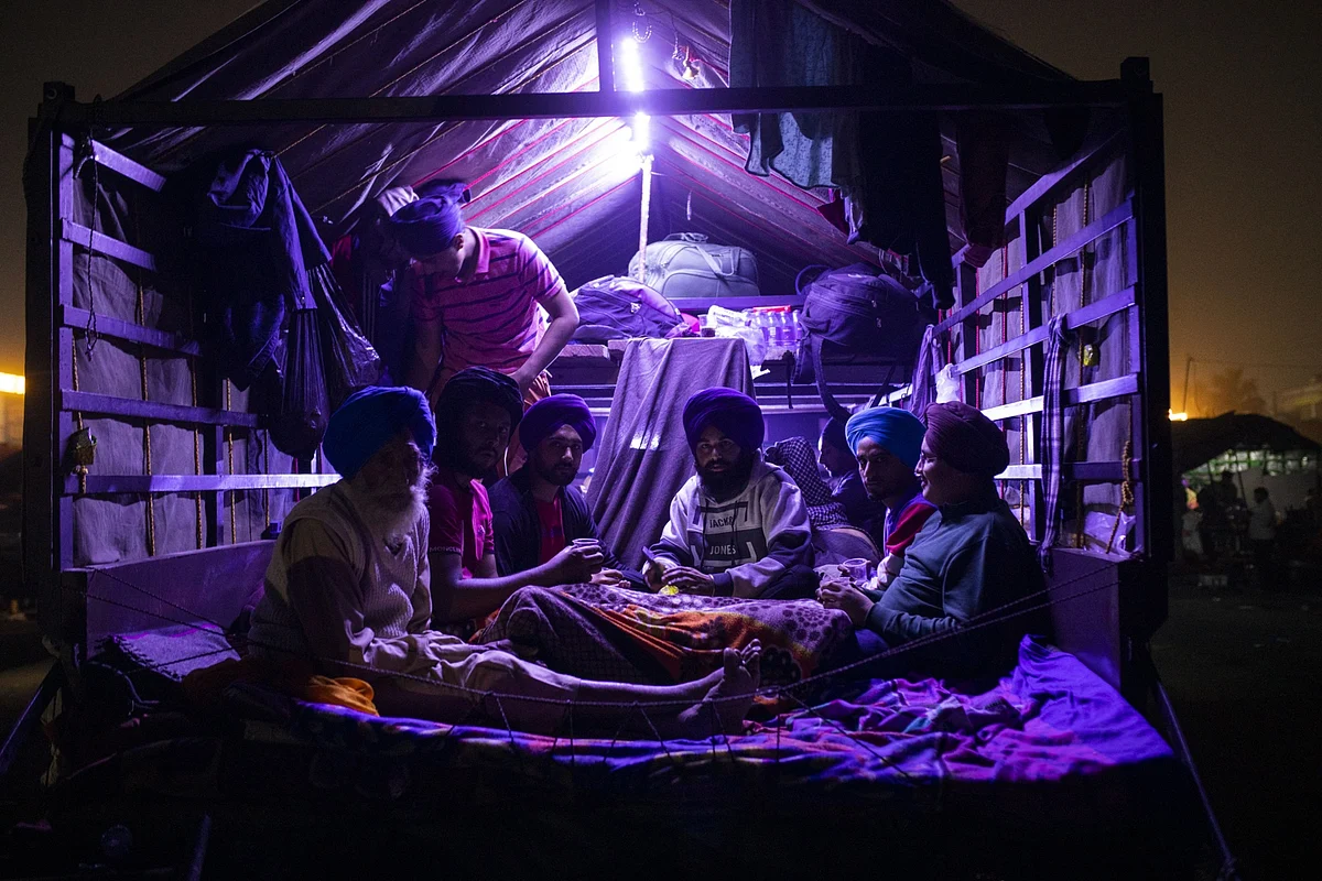 Farmers sit inside a tractor trailer at a protest site at a road block on the Delhi-Haryana border crossing in Singhu, Delhi, India. (Photographer: Prashanth Vishwanathan/Bloomberg)