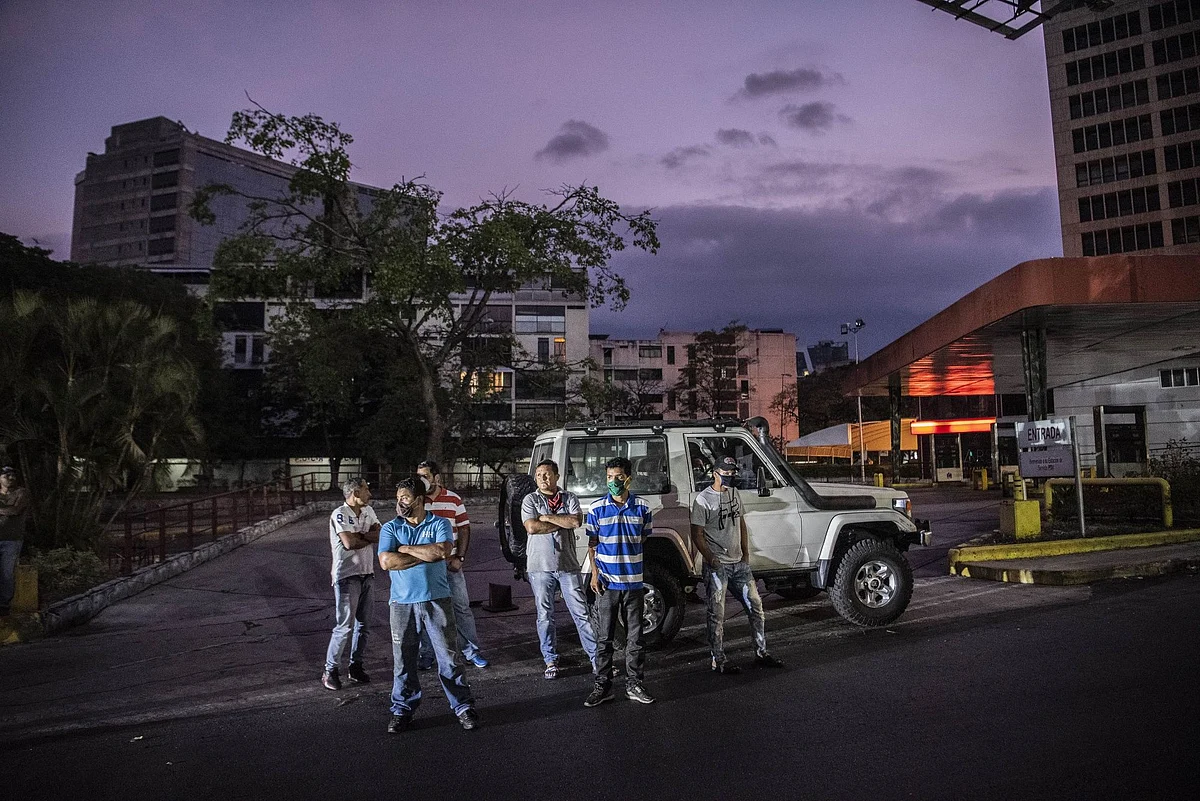 Drivers stand at a gas station in Caracas on May 26. Venezuelan President Nicolás Maduro had said fuel prices would increase starting in June. Photographer: Carlos Becerra/Bloomberg 
