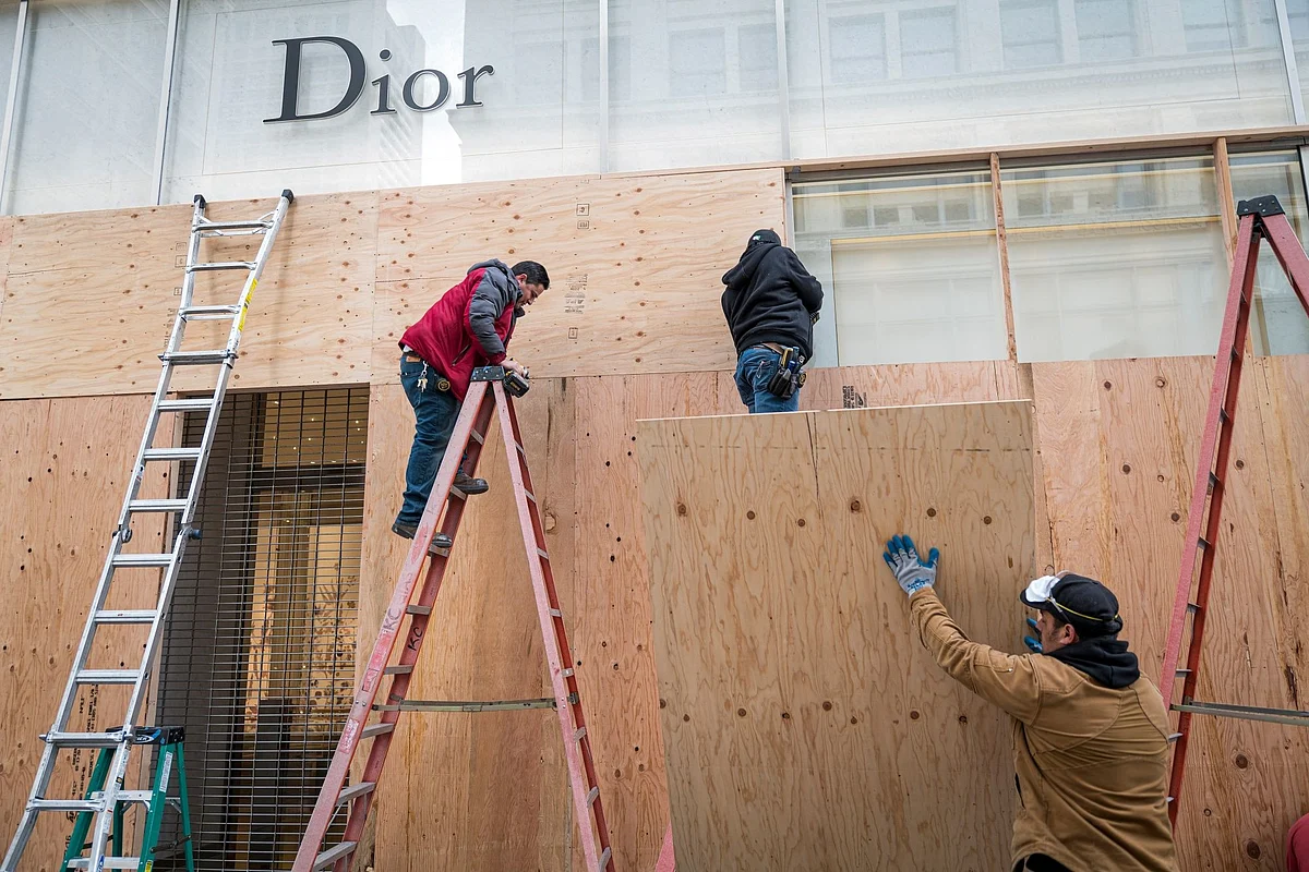 Workers board up the windows of a Christian Dior store in San Francisco on March 17 after people were ordered to stay home. Photographer: David Paul Morris/Bloomberg 