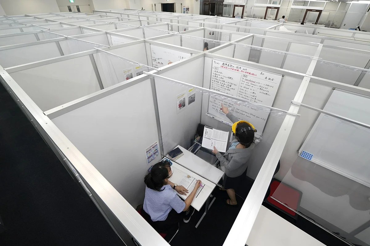 An instructor teaches a student through a plastic barrier at a school in Tokyo on Aug. 13. Photographer: Toru Hanai/Bloomberg 
