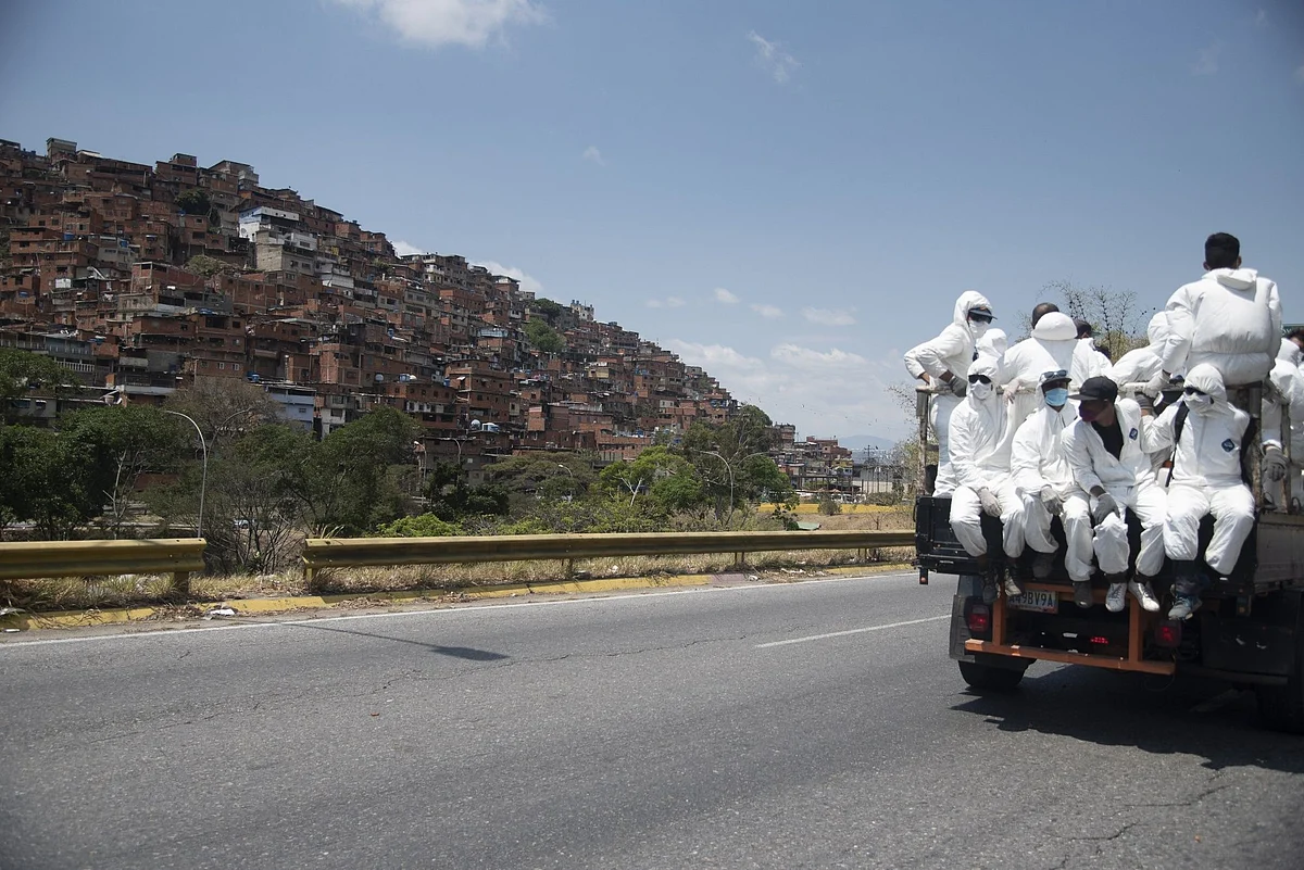 City workers in protective gear drive through Caracas on March 26. Venezuela is also facing a growing food insecurity crisis. Photographer: Carlos Becerra/Bloomberg