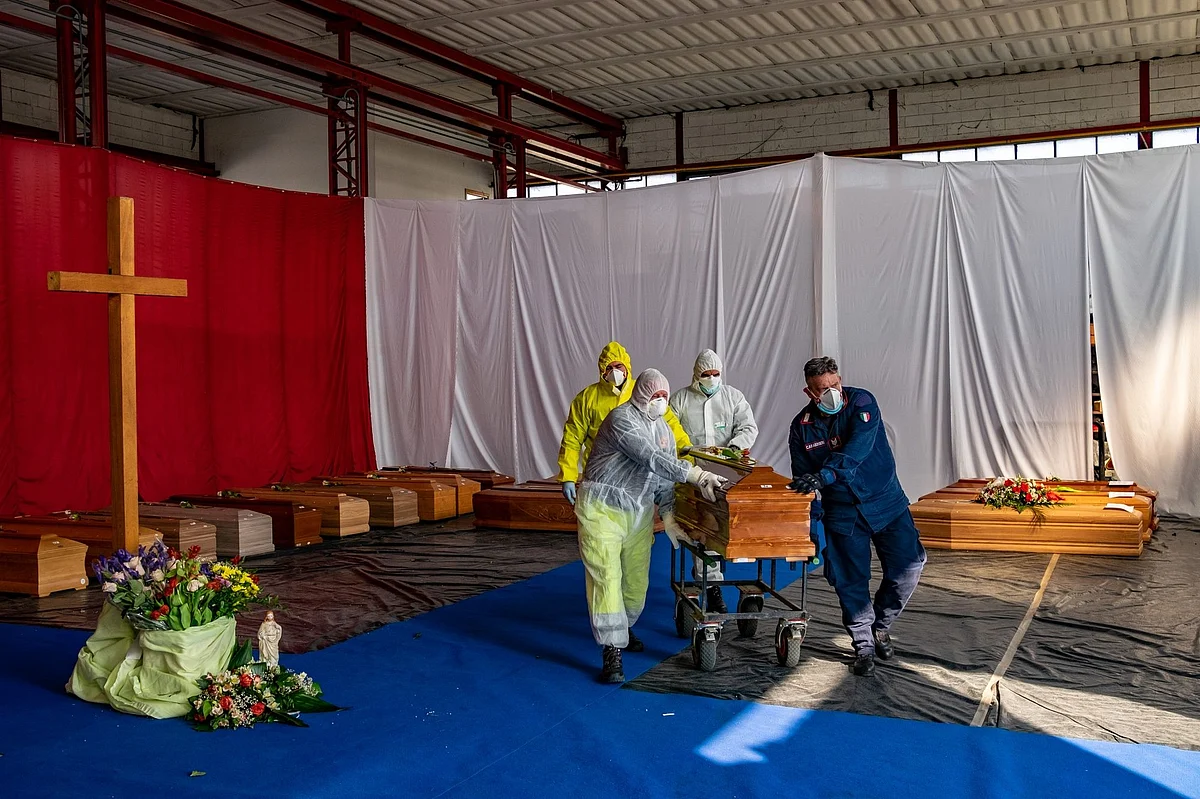 Civil protection members and police transport a coffin from a repurposed warehouse to a crematorium near Bergamo, Italy, on April 4. Photographer: Francesca Volpi/Blooomberg