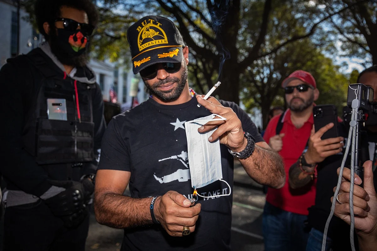 During a post-election Trump rally in Atlanta on Nov. 21, Enrique Tarrio, leader of the far-right group Proud Boys, sets a face mask alight. Republican efforts to void Joe Biden’s victory failed in the courts. Photographer: Dustin Chambers/Bloomberg 