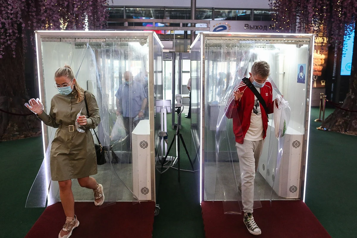 Shoppers pass through disinfection cabins at the Evropeysky Shopping Center in Moscow on Aug. 11. Photographer: Andrey Rudakov/Bloomberg 